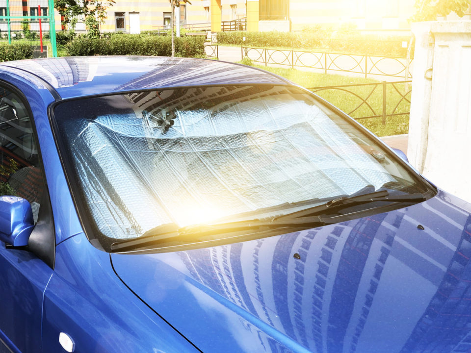 Protective reflective surface under the windshield of the passenger car parked on a hot day, heated by the sun's rays inside the car