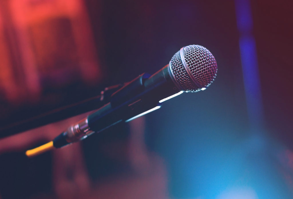 Microphone on the stage on blue and red dark background.